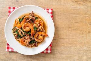 Stir-fried seafood of shrimps and squid with Thai basil - Asian food style photo
