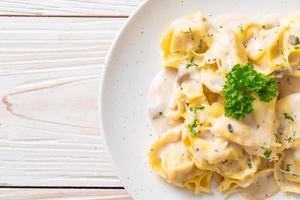 Tortellini pasta with mushroom cream sauce and cheese - Italian food style photo