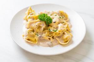 Tortellini pasta with mushroom cream sauce and cheese - Italian food style photo