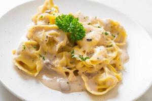 Tortellini pasta with mushroom cream sauce and cheese - Italian food style photo