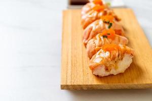 Grilled salmon sushi on a wood plate - Japanese food style photo