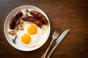 Homemade double fried egg with fried pork sausage - for breakfast photo