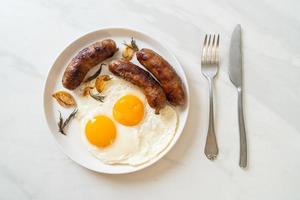 Homemade double fried egg with fried pork sausage - for breakfast photo