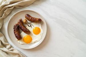 Homemade double fried egg with fried pork sausage - for breakfast photo