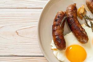 Homemade double fried egg with fried pork sausage - for breakfast photo