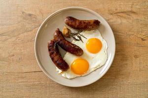 Homemade double fried egg with fried pork sausage - for breakfast photo