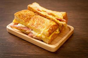 tostada francesa casera con sándwich de jamón, tocino y queso con huevo foto