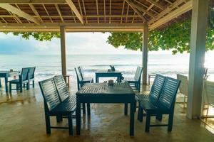 Empty wooden chairs with beach sea background photo