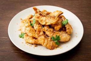 Fried fish with garlic on plate photo