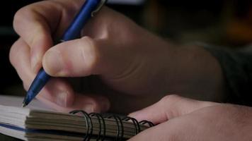 close-up de um homem escrevendo notas em um caderno video