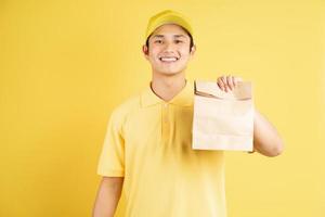 Repartidor retrato sosteniendo una bolsa de compras, de la mano al igual que en el fondo foto