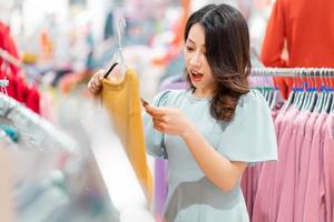 Young girl is choosing to buy clothes at the mall photo