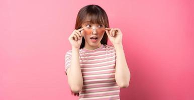 Image of young Asian girl wearing pink t-shirt on pink background photo