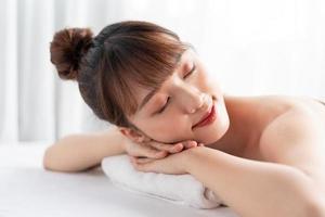 Young asian woman taking care of body at spa photo