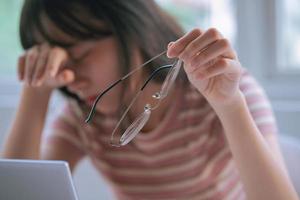 Young Asian girl tired of working long time on computer photo