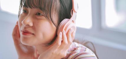 Joven mujer asiática con auriculares inalámbricos para escuchar música foto
