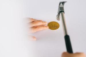 Mujer asiática con un martillo para romper su moneda foto