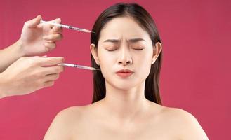 Young Asian woman feeling scared when injecting filler photo