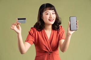 Asian woman holding bank card and holding phone with blank screen photo