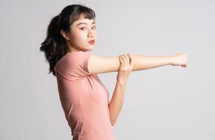 Young Asian woman doing exercise on white background photo