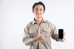 The male machine engineer was standing holding the phone and pointing at it photo