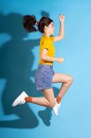 Young Asian girl posing on blue background photo