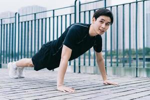 Young Asian man exercising in park photo