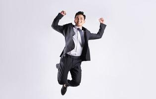 Young Asian businessman jumping on white background photo