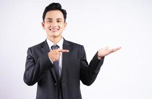 Imagen del joven empresario asiático vistiendo traje sobre fondo blanco. foto