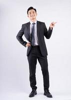 Young Asian businessman standing on white background photo