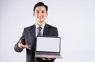 Young Asian businessman using laptop on white background photo