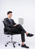 Young Asian businessman sitting on chair on white background photo