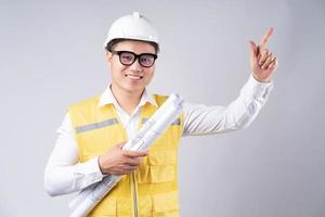 Asian engineer holding drawing on gray background photo