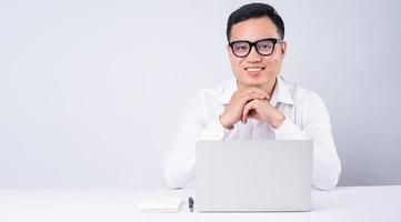 Asian businessman using laptop on white background photo