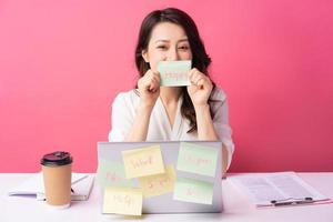 Young Asian businesswoman sitting working with expression on background photo