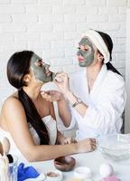 two beautiful women applying facial mask doing spa procedures photo