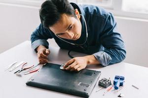 The Asian man was taking out a broken computer to repair it photo