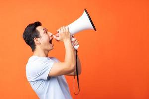 Asian man holding megaphone and shouting photo