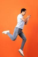 Asian businessman jumping and holding smartphone photo