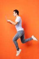 Asian businessman jumping and holding laptop photo