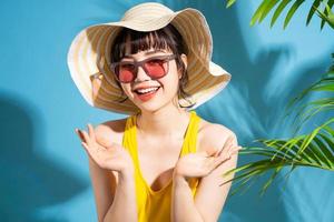 Beautiful Asian woman wearing yellow jumpsuit on blue background and, summer concept