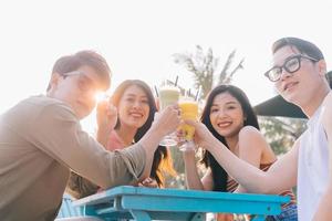 un grupo de jóvenes asiáticos disfrutan de un viaje al mar en unas vacaciones de verano foto