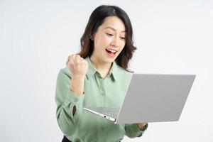 Portrait of the beautiful Asian businesswoman looking at the laptop screen with a successful expression photo