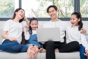 Young Asian family entertained at home in free time photo