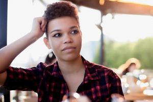 Beautiful African American woman with short hair in the summer on the street photo