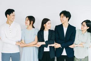Asian young business people are holding hands to show solidarity photo
