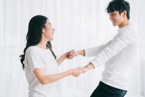 pareja asiática bailando juntos en el dormitorio foto