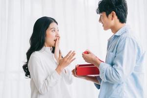 chica asiática se siente feliz y sorprendida de recibir regalos de su novio el día de san valentín