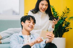 Asian couple playing games at home together, the happy life of a newlyweds photo