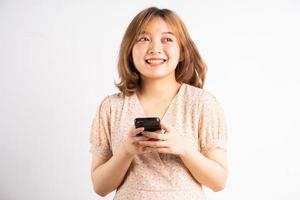 Young Asian girl holding phone with expressions, gestures on background photo